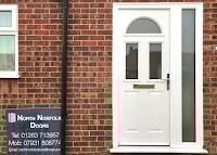White composite front door with arched window on red brick house facade