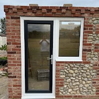 Brick exterior with white-framed glass door and window entrance