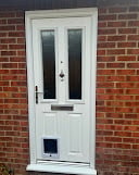 White front door with glass panels on a red brick house
