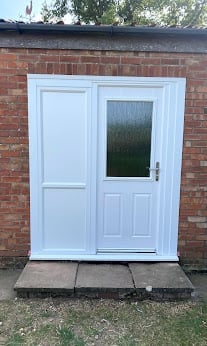 White double doors with glass panel on red brick wall with concrete step